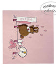 Baby shower card with a bear and baby items on a pink background, featuring 'It's a girl' text.