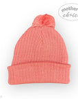 Pink knit beanie with a pom-pom on a white background, featuring 'mother's choice' branding.