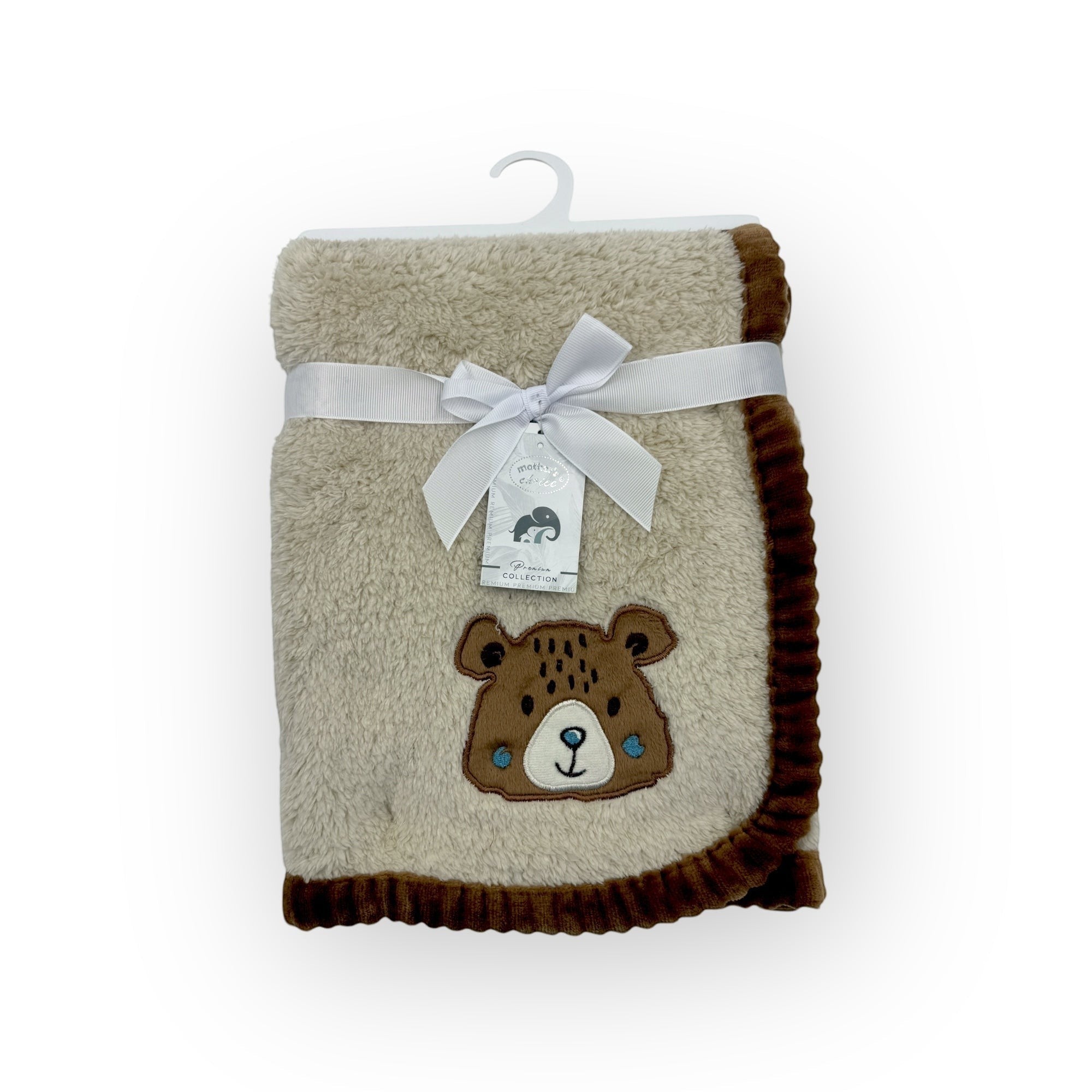 Folded blanket with bear design and white ribbon on a white background