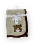 Folded blanket with bear design and white ribbon on a white background