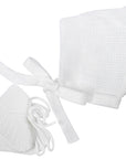 White baby bonnet and booties set on a white background