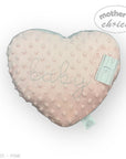 Heart-shaped pink pillow with 'baby' embroidery and 'Mother's Choice' tag on a white background