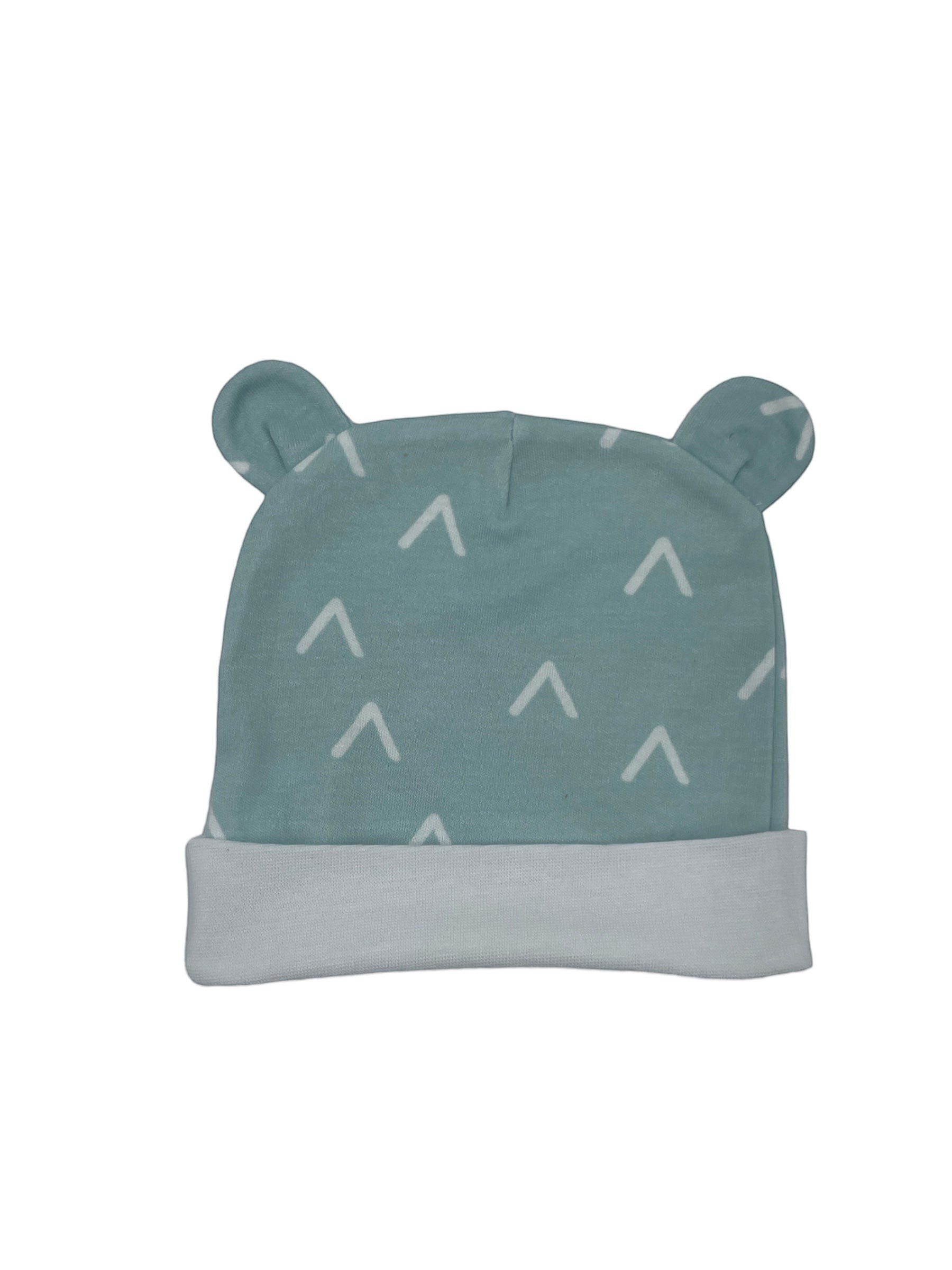 Green baby hat with white patterns on a white background