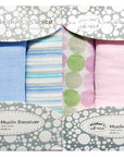 Packaged muslin swaddles with various patterns in a branded box.