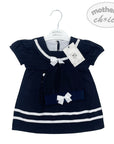Navy blue dress with white accents on a hanger, branded 'Mother's Choice'.