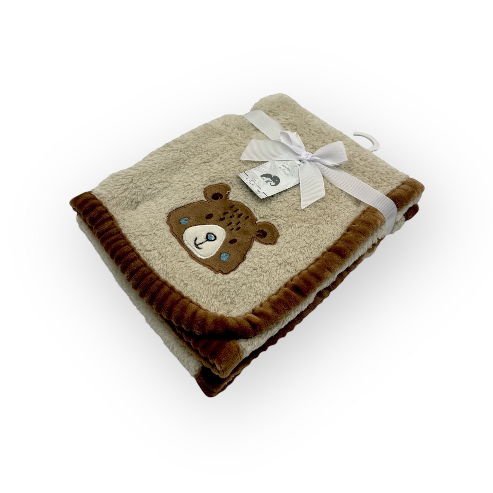 Folded blanket with a teddy bear design and a white ribbon on a white background