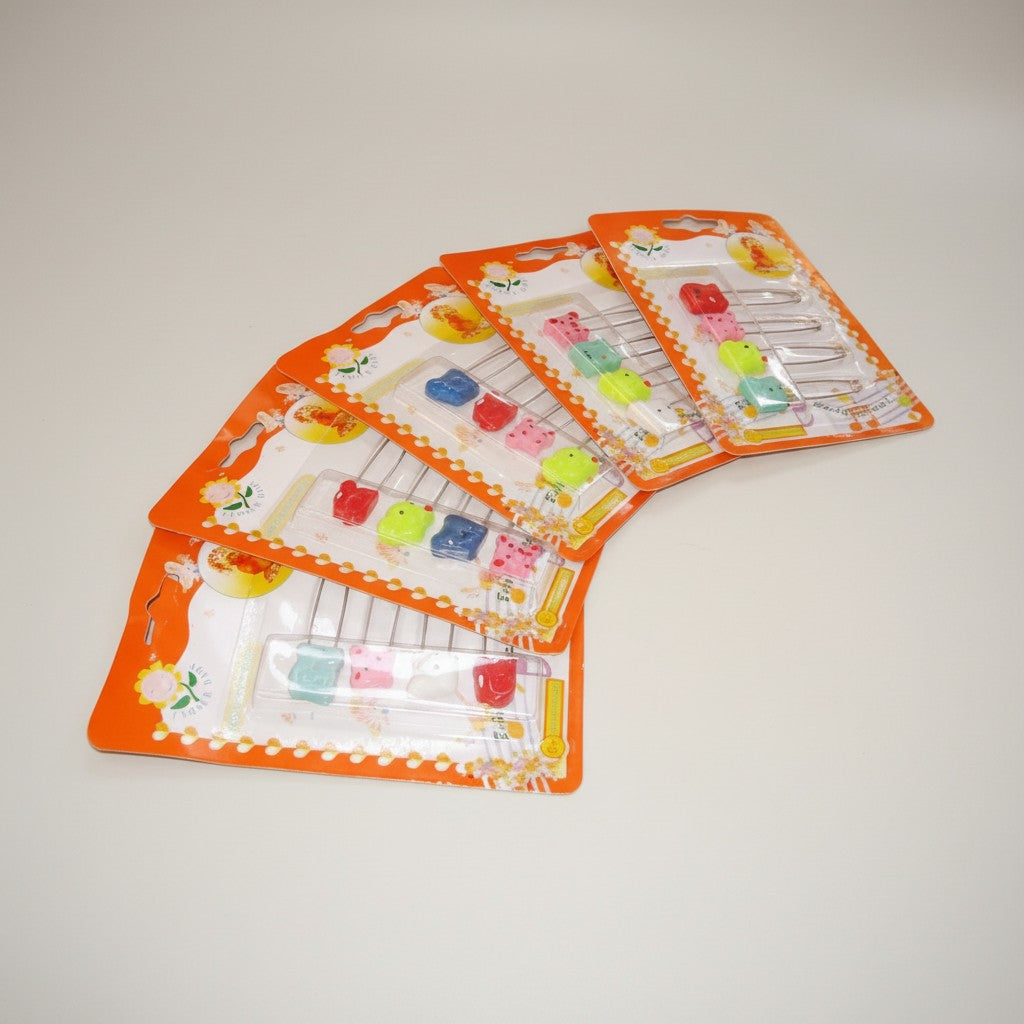 Set of colorful safety pins in packaging on a light gray background