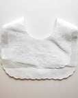 White scalloped bib on a light gray background