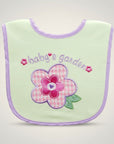 Light green baby bib with pink flower and 'baby's garden' text on a light gray background