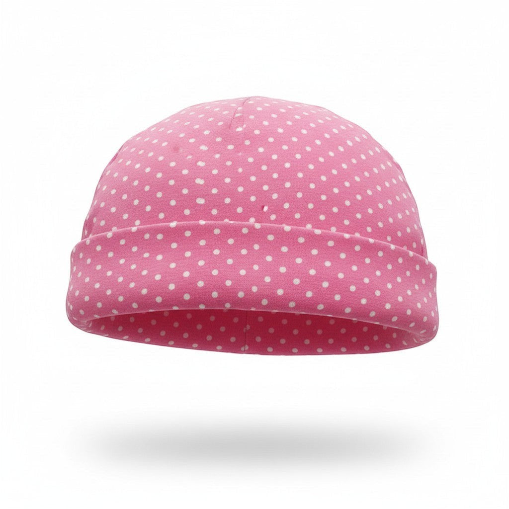 Pink beanie with white polka dots on a white background