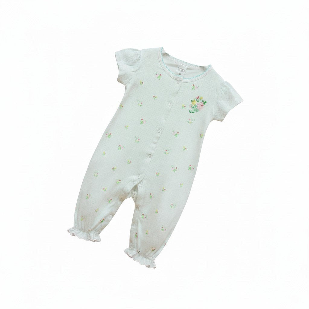 White baby romper with floral patterns on a white background