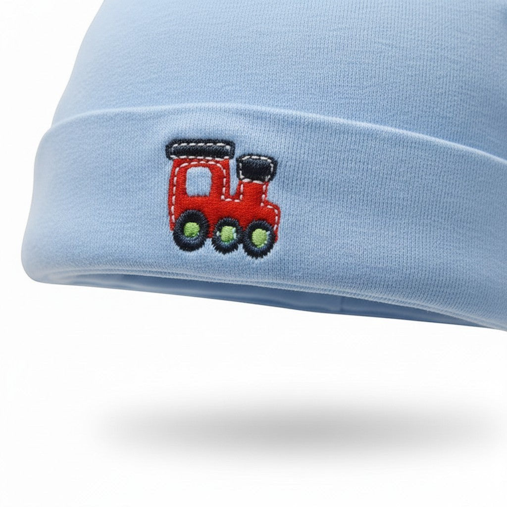 Light blue baby hat with a red train design on a white background