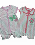 Two baby rompers with butterfly and flower designs on a white background