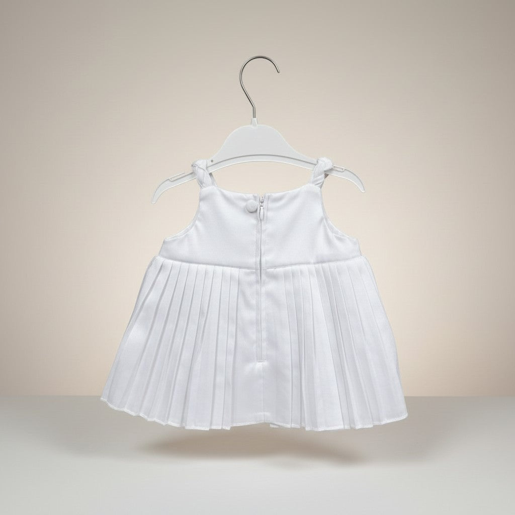 White pleated dress on a hanger against a beige background