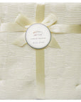 White textured blanket with a yellow ribbon and 'Mother's Choice' tag