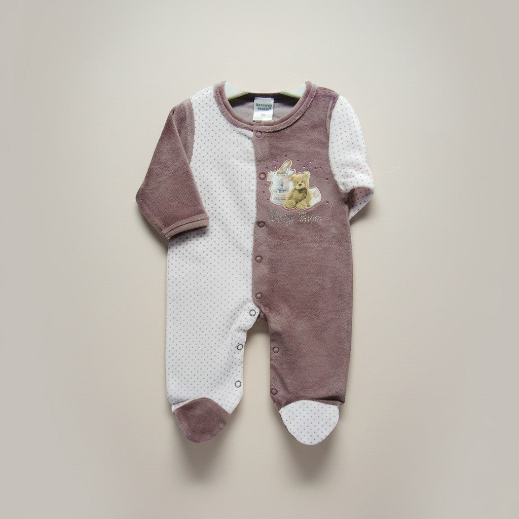 Baby onesie with teddy bear design on a beige background