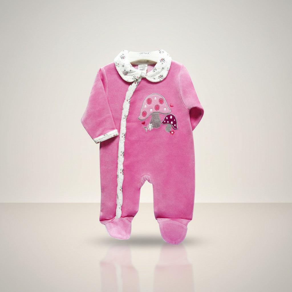 Pink baby onesie with mushroom design on a light gray background