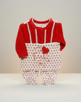 Red and white baby outfit with polka dot pattern on a neutral background