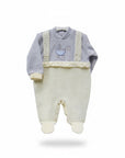 Baby outfit with light blue top and cream pants on a white background