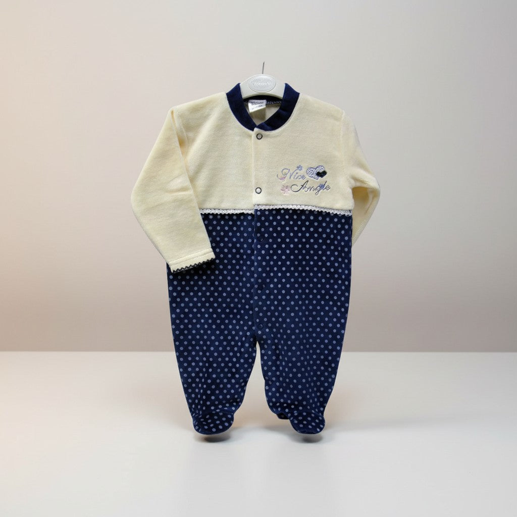 Baby outfit with cream top and navy polka dot pants on a white background