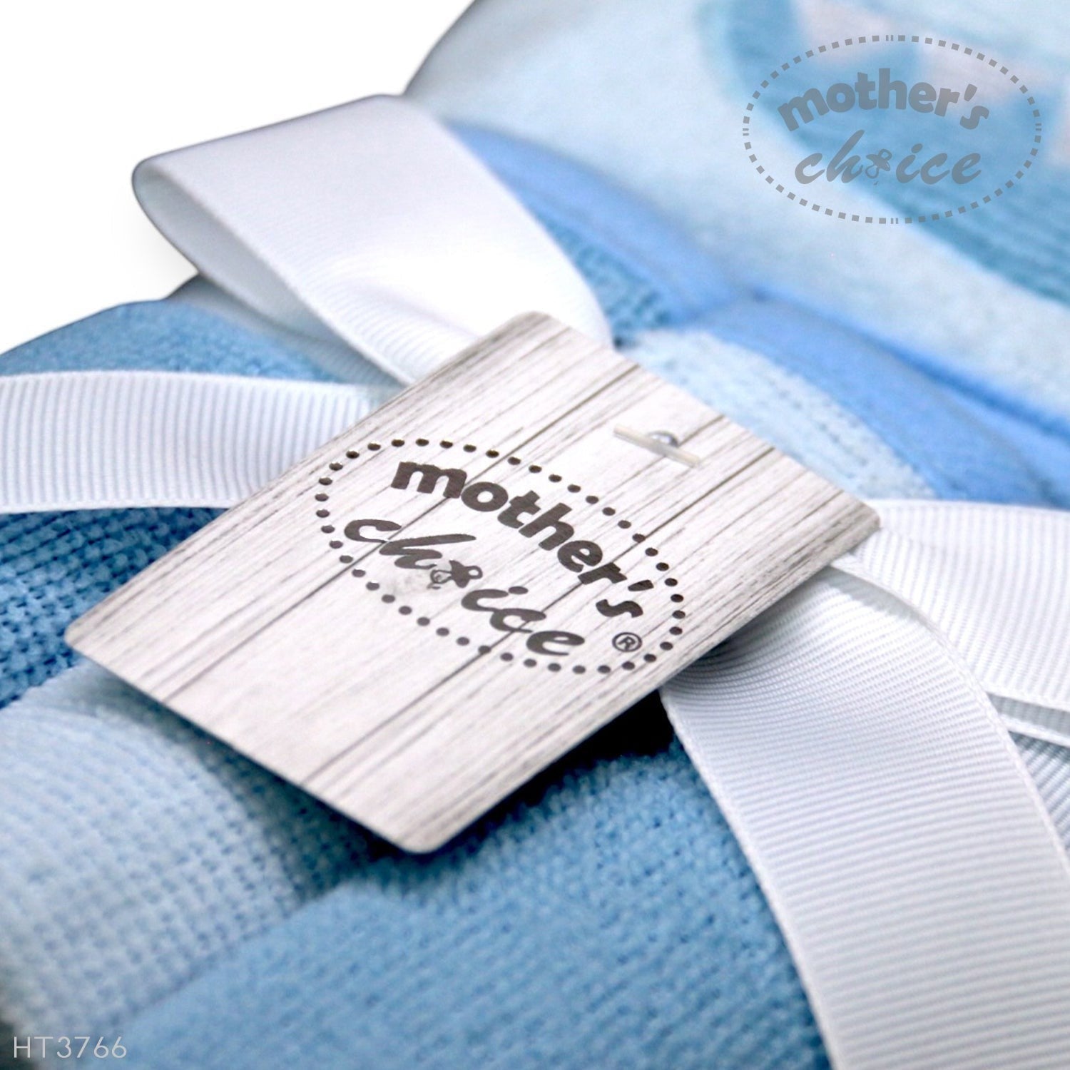 Close-up of a 'mother's choice' label on a blue blanket with white ribbons.