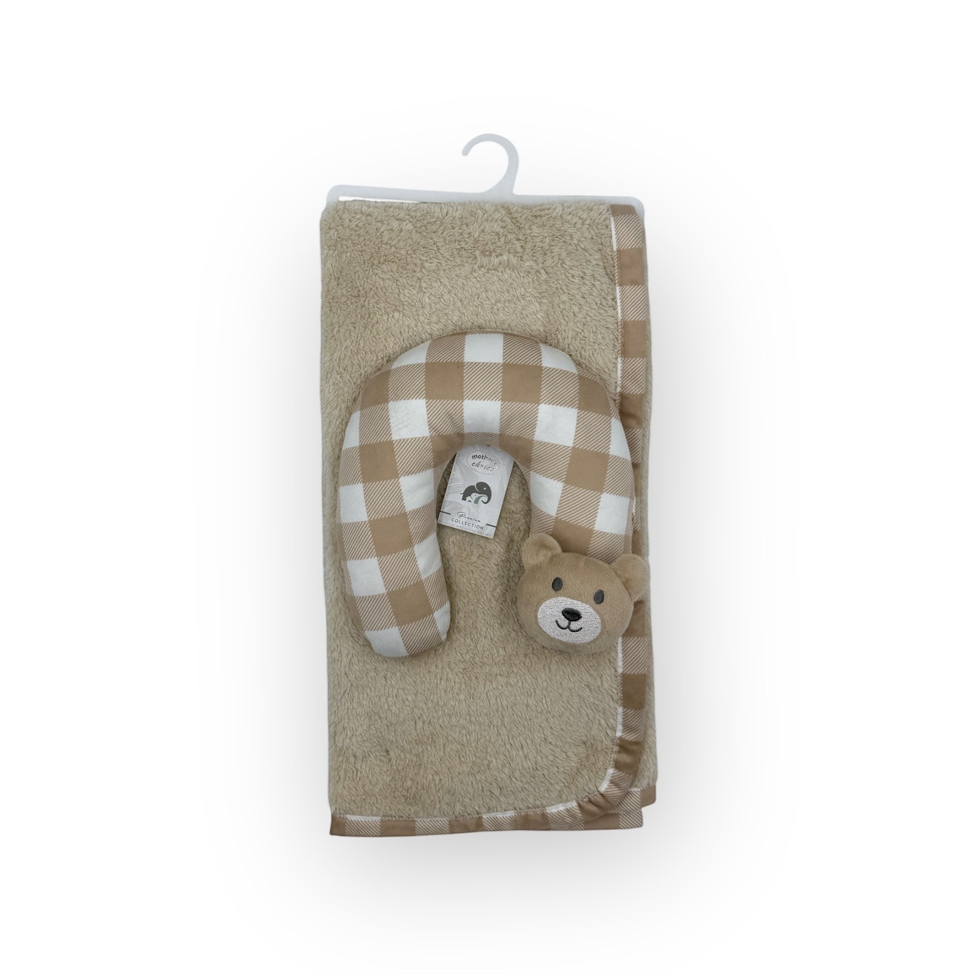 Plush toy with checkered pattern and bear face on a beige blanket with a white background