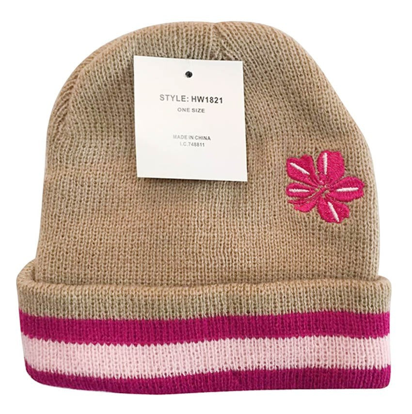 Beige knit beanie with pink flower design and striped band on a white background