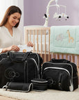 Stork And Baby 4-piece black nappy bag set with white stitching and circular design. Includes large bag, smaller bag, and two pouches.
