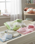 Stork And Baby 3 piece baby gift set with hat, sponge, and mitten in green, pink, and blue with animal embroidery.