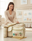 Stork And Baby beige nappy bag with Little Friends embroidery and multiple compartments, perfect for baby essentials.