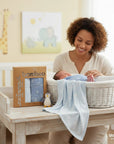 Stork And Baby blue bamboo cotton jersey wraps, 2 pack, 80x80cm, with tree pattern. A mother smiles at her baby.