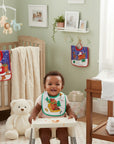 Stork And Baby infants Christmas themed pullover toweling bib with a bear on a sled design. Absorbent fabric for feeding spills.