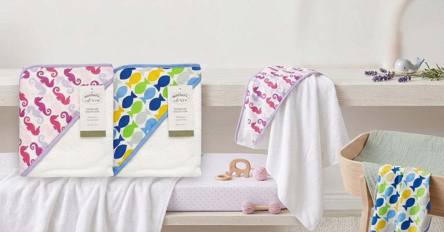 Stork And Baby 100% cotton hooded towel with playful sea creature designs in pink seahorse and blue fish patterns.