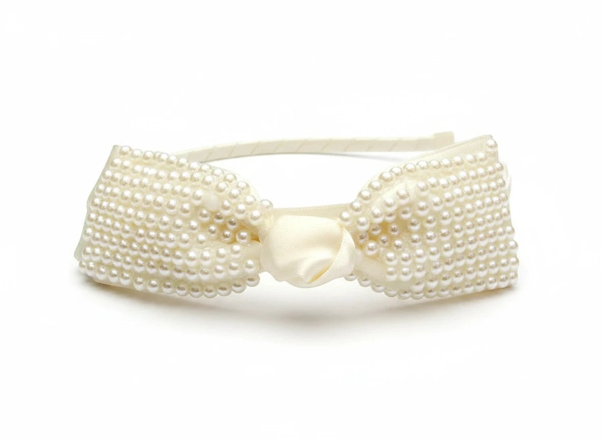 Stork And Baby cream satin girls alice band featuring a large bow embellished with delicate white pearls.