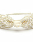 Stork And Baby cream satin girls alice band featuring a large bow embellished with delicate white pearls.