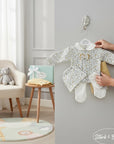 Stork And Baby Girls 5-piece yellow and grey floral print newborn set with footed pajamas, hat, and mittens.