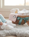 Stork And Baby white christening booties for girls with butterfly embroidery and convenient hook-and-loop strap.