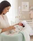 Stork And Baby white tulle wedding veil with bow for girls, worn by a newborn in a nursery setting.