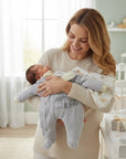 Stork And Baby grey padded velour baby grower with house embroidery. Gentle on skin, ideal for cooler days.