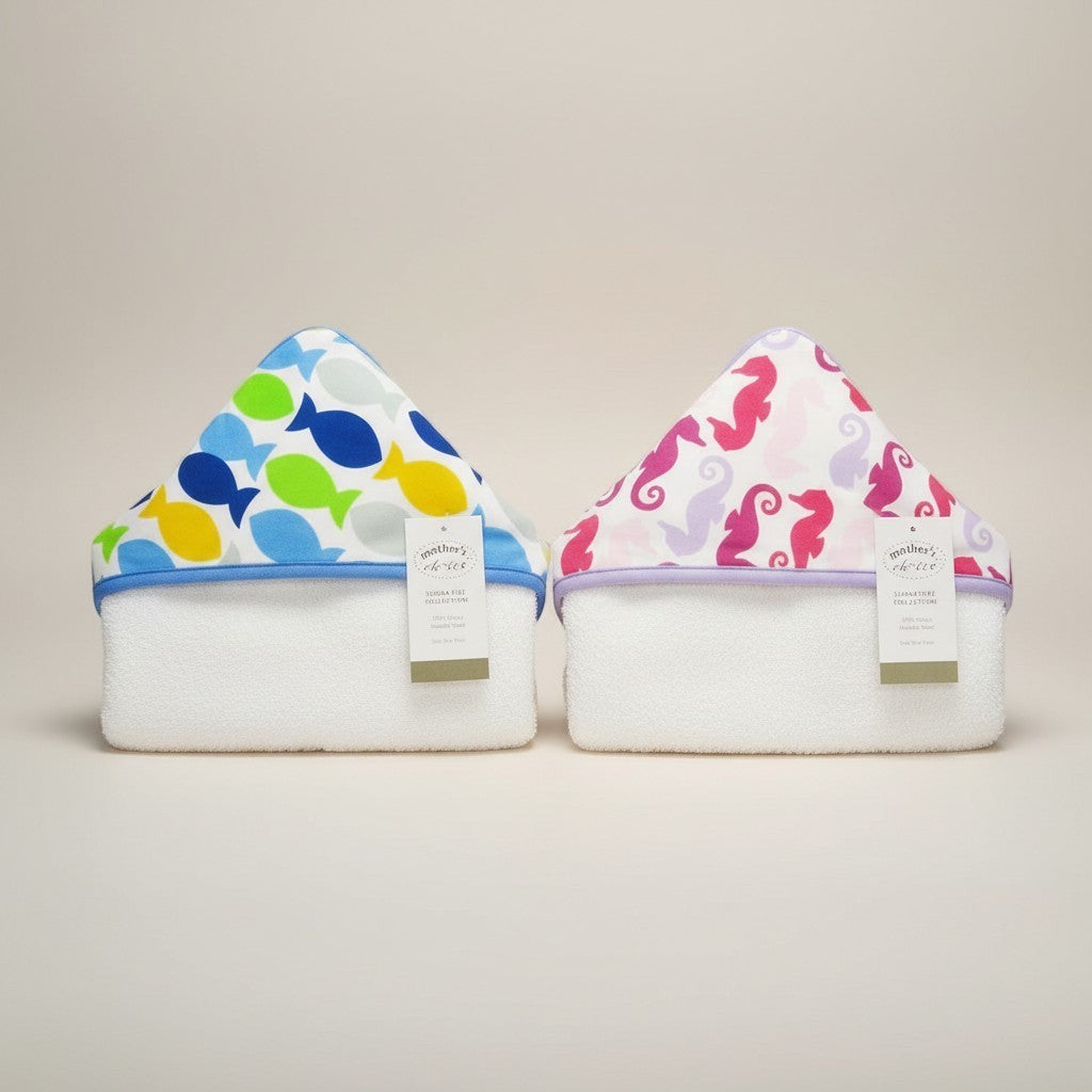 Stork And Baby hooded cotton towels in blue fish and pink seahorse prints. 100% cotton, absorbent, and soft for baby bath time.