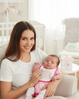 Stork And Baby white cotton top with lace trim, worn by a smiling woman holding a baby in a pink heart-print 3-piece starter set.
