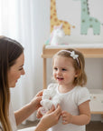 Stork And Baby infant hair accessory set featuring a white butterfly headband with diamante and a soft white scrunchie