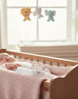 Stork And Baby infant girls white polka dot crown hair accessory resting in a crib next to a sleeping baby.