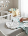 Stork And Baby white infants pull on Nicky pants and a light blue muslin swaddle with animal print.