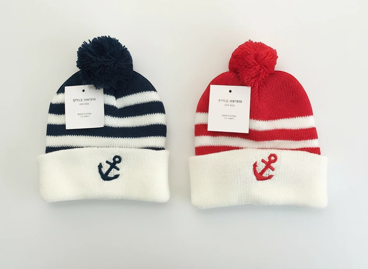 Stork And Baby Infants winter hat in navy and red stripes with white cuff and anchor embroidery. Features a pom-pom.
