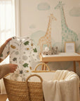 Stork And Baby white cotton babygrow with mint art print, featuring giraffes and stars. Easy zip design.