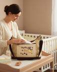 Stork and Baby Moon Diaper Bag in beige with brown trim, featuring a cute bear embroidery and organized compartments.