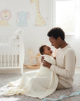 Stork And Baby Mothers Choice ecru cellular blanket made of 100% cotton, used by a mother to swaddle her happy baby.