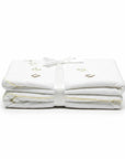Stork And Baby Mothers Choice beige cotton jersey baby wrap with delicate embroidery, tied with a white ribbon.