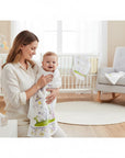 Stork And Baby Mothers Choice infants cutwork blanket with fairytale print, wrapped around a smiling baby held by mom.